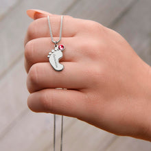 Load image into Gallery viewer, Hand holding silver footprint necklace with birthstone