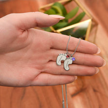 Load image into Gallery viewer, Hand holding silver 2-footprints necklace with birthstones