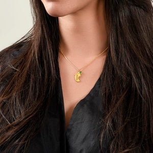 Woman wearing gold footprint necklace with birthstone